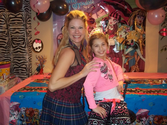 melanie from party pals poses for a photo with the birthday girl during a monster high theme birthday party